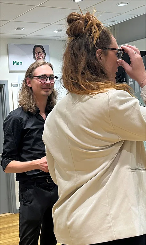 Optikerassistent Isaac Morten hjälper en kund att välja rätt bågar.