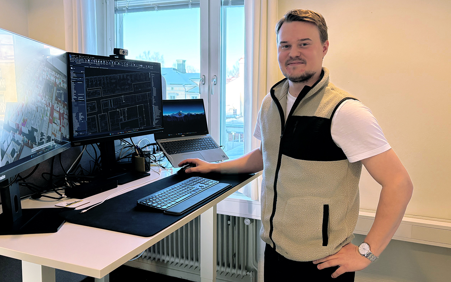 Erik Lindström som läser till Elkonstruktör på TUC Yrkeshögskola i Skellefteå står vid ett skrivbord med tre datorskärmar. På skärmarna syns CAD-ritningar